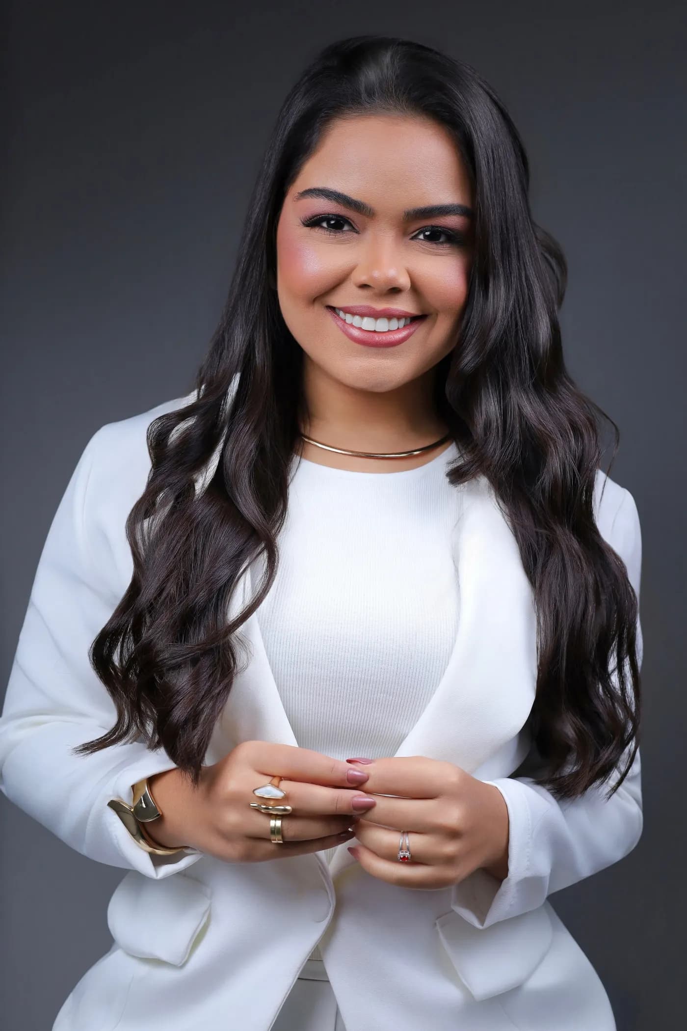 Dra. Darlyana Lemos sorrindo, com traje branco, em retrato profissional